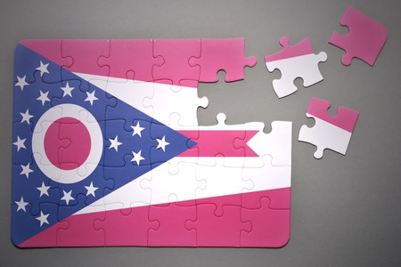 broken puzzle with the flag of ohio state on a gray backgroundの写真素材