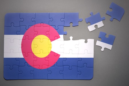broken puzzle with the flag of colorado state on a gray backgroundの写真素材
