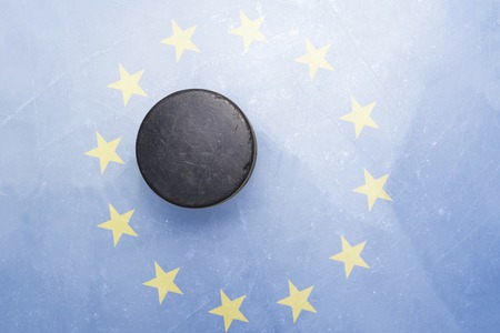 vintage old hockey puck is on the ice with european union flag