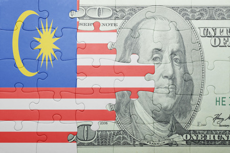 puzzle with the national flag of malaysia and dollar banknote . conceptの写真素材