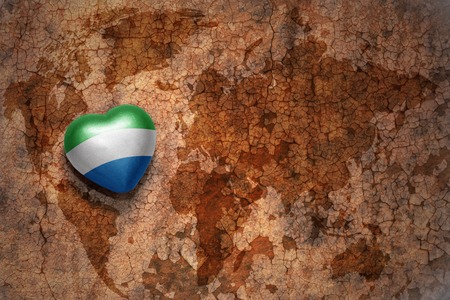 heart with national flag of sierra leone on a vintage world map crack paper background. conceptの写真素材