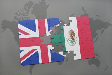 puzzle with the national flag of great britain and mexico on a world map background.の写真素材