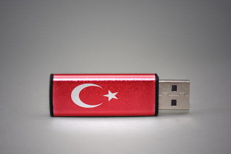usb flash drive with the national flag of turkey on gray background. concept