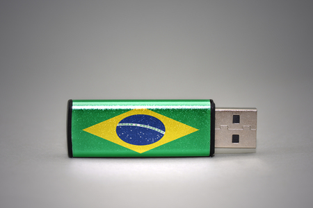 usb flash drive with the national flag of brazil on gray background. concept