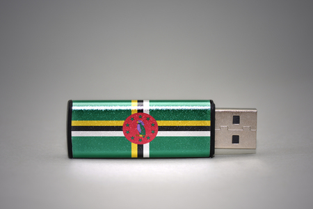 usb flash drive with the national flag of dominica on gray background. concept