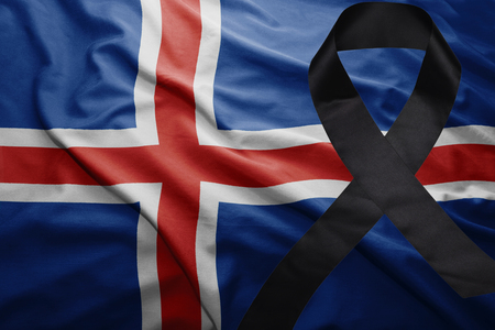 waving national flag of iceland with black mourning ribbonの写真素材