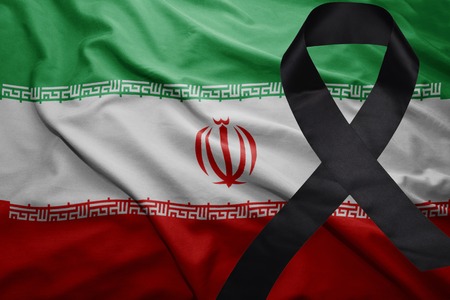 waving national flag of iran with black mourning ribbonの写真素材