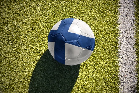 football ball with the national flag of finland lies on the green field near the white lineの写真素材