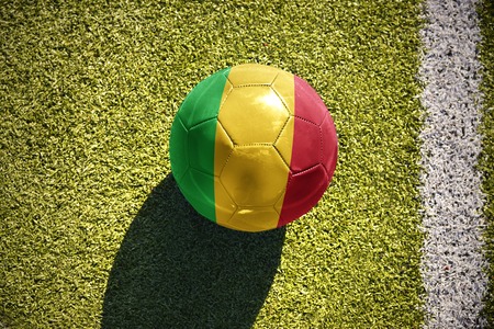 football ball with the national flag of mali lies on the green field near the white lineの写真素材