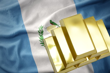 gold reserves. shining golden bullions on the guatemala flag backgroundの写真素材