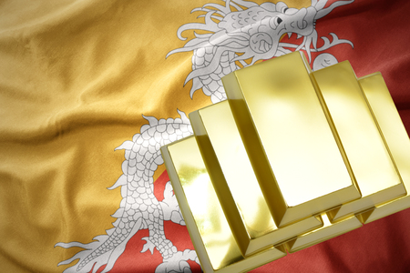 gold reserves. shining golden bullions on the bhutan flag backgroundの写真素材