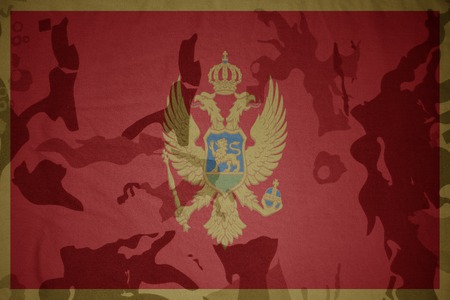 flag of montenegro on the khaki texture background. military conceptの写真素材