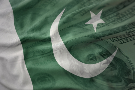 colorful waving national flag of pakistan on a american dollar money background. finance conceptの写真素材