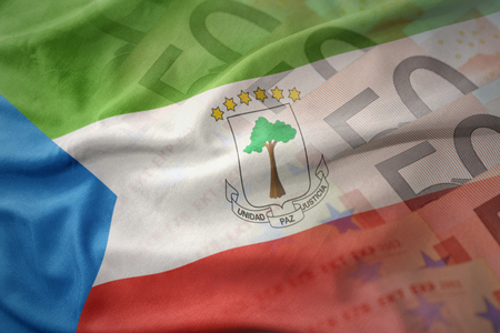 colorful waving national flag of equatorial guinea on a euro money banknotes background. finance conceptの写真素材