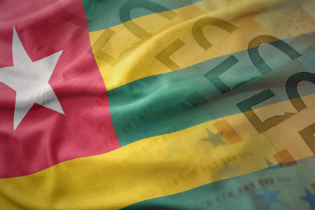 colorful waving national flag of togo on a euro money banknotes background. finance conceptの写真素材