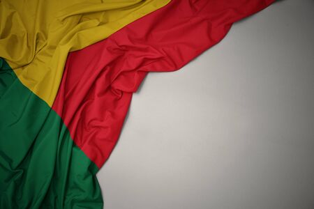 waving colorful national flag of benin on a gray background.の写真素材