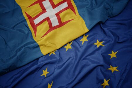 waving colorful flag of european union and national flag of madeira. macroの写真素材