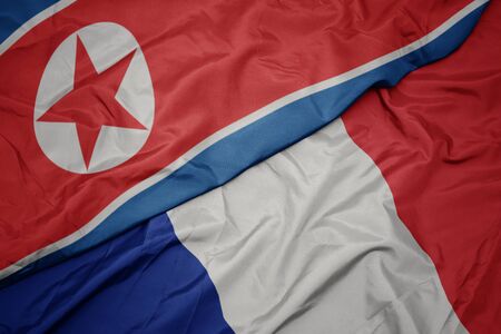 waving colorful flag of france and national flag of north korea. macroの写真素材