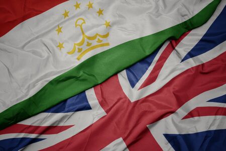 waving colorful flag of great britain and national flag of tajikistan. macroの写真素材