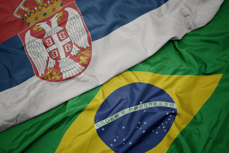 waving colorful flag of brazil and national flag of serbia. macroの写真素材
