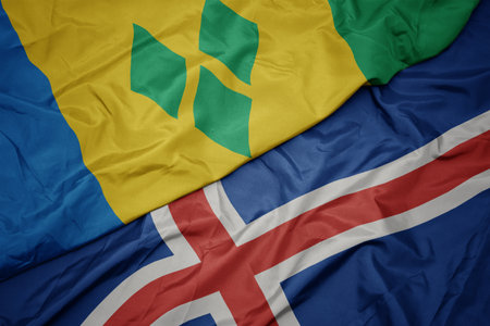 waving colorful flag of iceland and national flag of saint vincent and the grenadines. macroの写真素材