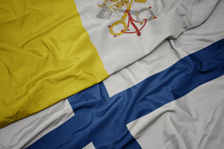 waving colorful flag of finland and national flag of vatican city. macroの写真素材