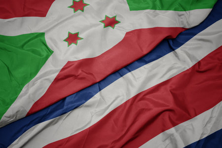 waving colorful flag of costa rica and national flag of burundi . macroの写真素材