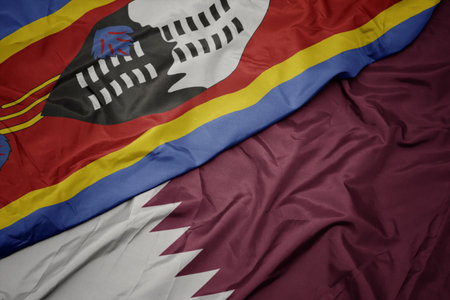 waving colorful flag of qatar and national flag of swaziland. macroの写真素材