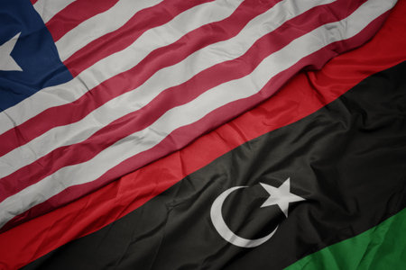 waving colorful flag of libya and national flag of liberia. macroの写真素材