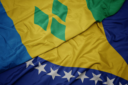 waving colorful flag of bosnia and herzegovina and national flag of saint vincent and the grenadines. macroの写真素材