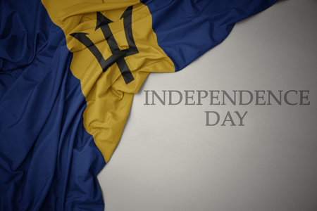 waving colorful national flag of barbados on a gray background with text independence day. conceptの写真素材