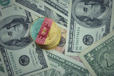 golden shining bitcoins with flag of cameroon on a dollar money background. bitcoin mining concept.の写真素材