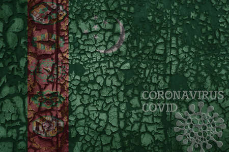 flag of turkmenistan on a old vintage metal rusty cracked wall with text coronavirus, covid, and...
