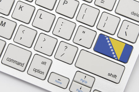 national flag of bosnia and herzegovina on the keyboard on a grey background. conceptの写真素材