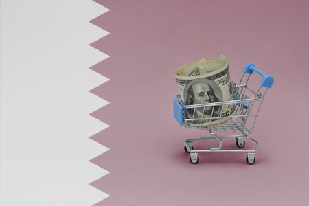 Metal shopping basket with big dollar money banknote on the national flag of qatar background. consumer basket concept. 3d illustrationの写真素材
