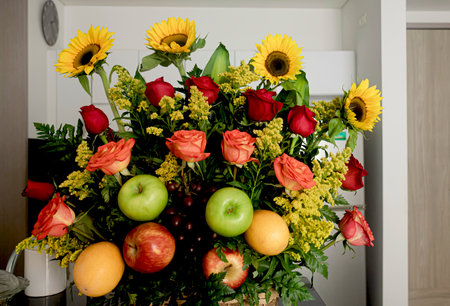 Bouquet of flowers and fruit on a table to surprise the person who's birthday.の写真素材