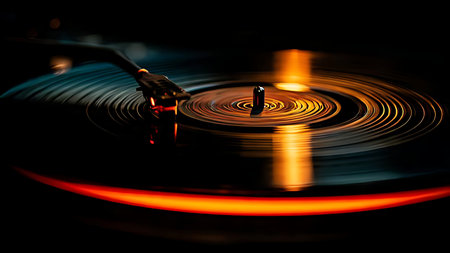 Vinyl record spinning with neon light reflection. Close-up detail of dust in grooves and black vinyl texture.の素材