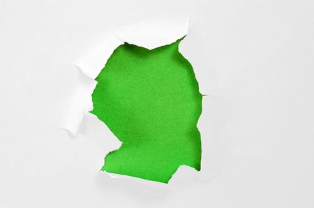 Hole torn in paper on green backgroundの写真素材