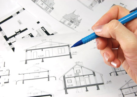 Architect with pencil and drawings of house