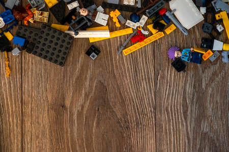 Colorful plastic bricks, cars and details of toys on black paper background. Parts of bright small spare parts for toys.の写真素材
