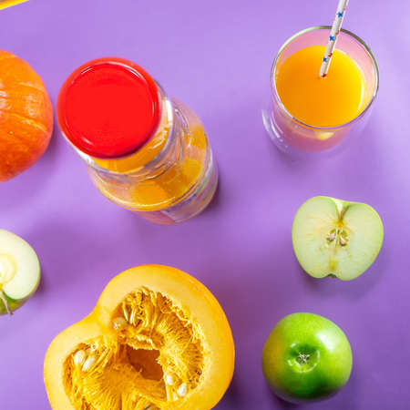 Fruit pumpkin apple carrot ginger on colored backgroundの写真素材