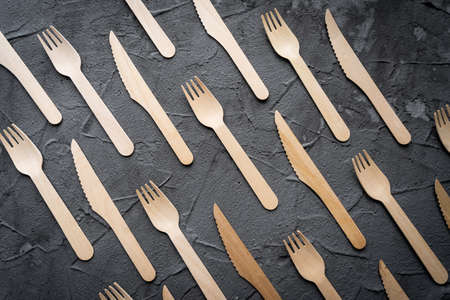 Wooden knife and fork on the black background. Eco friendly zero-waste concept. Top view with space for text Copy spaceの写真素材