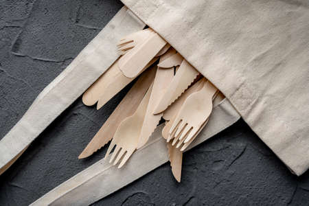 Wooden knife and fork on the black background. Eco friendly zero-waste concept. Top view with space for text Copy spaceの写真素材