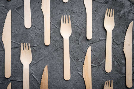 Wooden knife and fork on the black background. Eco friendly zero-waste concept. Top view with space for text Copy spaceの写真素材