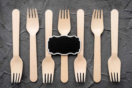 Wooden knife and fork on the black background. Eco friendly zero-waste concept. Top view with space for text Copy spaceの写真素材