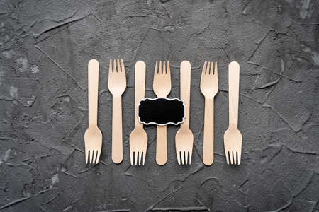 Wooden knife and fork on the black background. Eco friendly zero-waste concept. Top view with space for text Copy spaceの写真素材