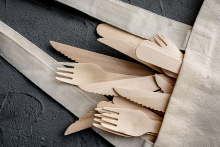 Wooden knife and fork on the black background. Eco friendly zero-waste concept. Top view with space for text Copy spaceの写真素材