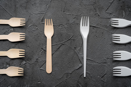 Wooden knife and fork on the black background. Eco friendly zero-waste concept. Top view with space for text Copy spaceの写真素材