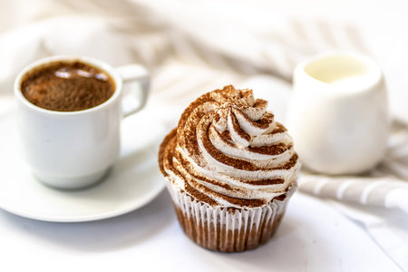Black coffee with cupcakes and muffins. Spice cupcakes with creamcheese frosting decorated with...