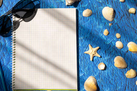 flat lay blue background blank notebook copy space. summer plans conceptの写真素材